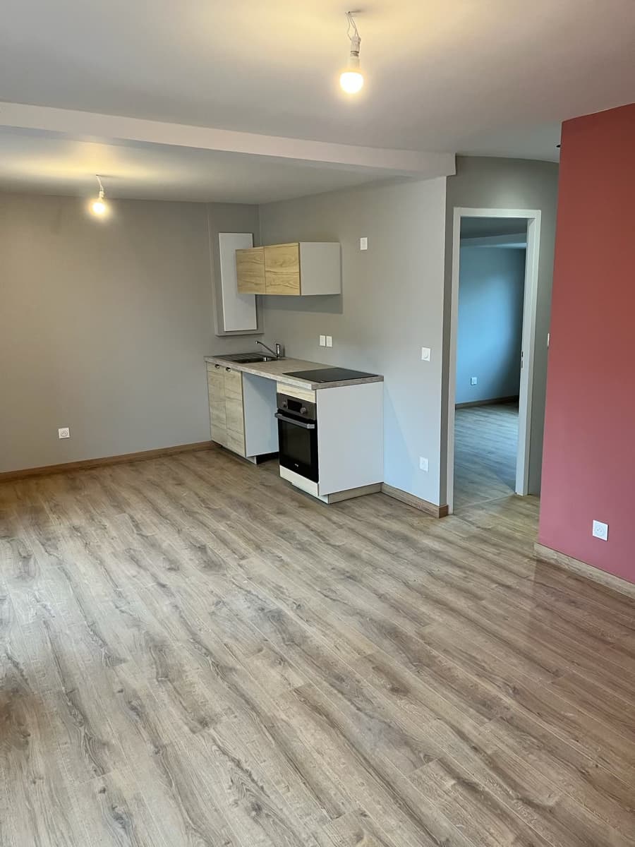 Cuisine moderne ouverte — meuble bois et blanc, mur rouge, parquet chêne