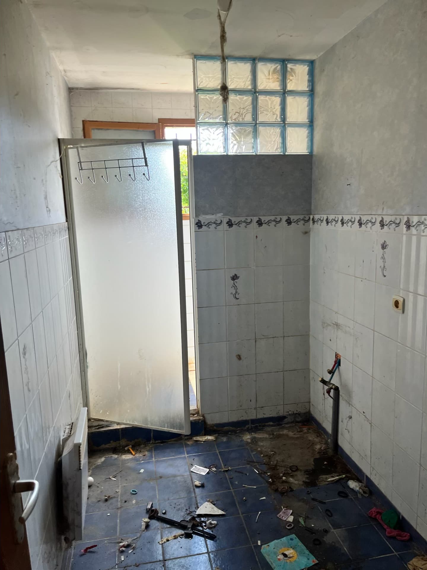 Ancienne salle de bain avant rénovation — carrelage vétuste, baignoire datée