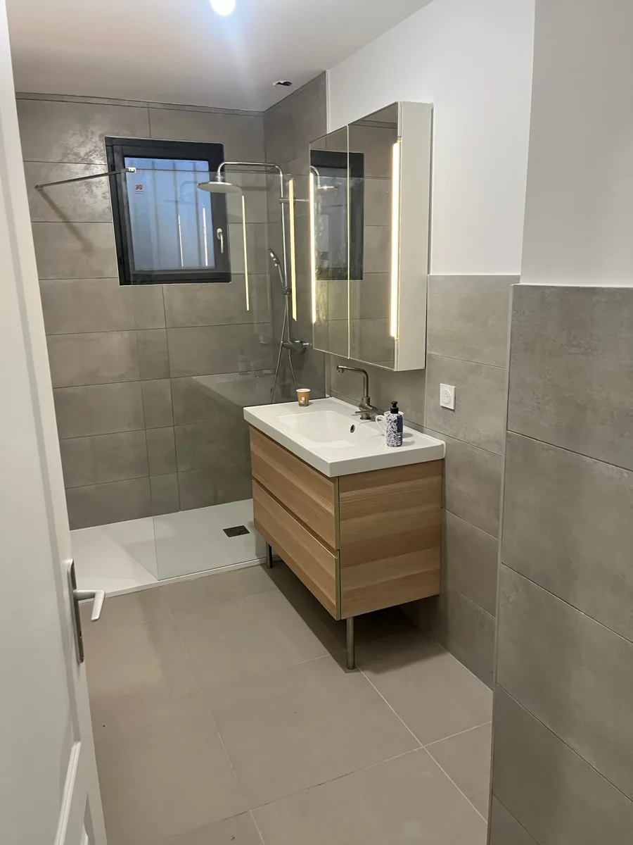 Salle de bain moderne rénovée à Dijon — carrelage gris béton, meuble vasque bois